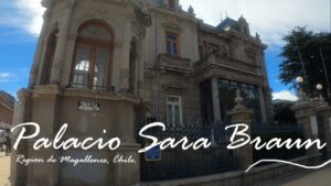 Un gran edificio histórico con una arquitectura ornamentada y rejas de hierro, el Palacio Sara Braun se erige como un legado cultural en Punta Arenas, Región de Magallanes, Chile, en un día soleado.
